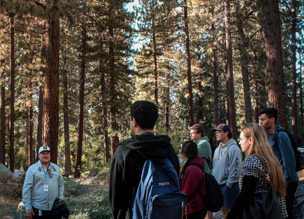 Prof. Jeffrey talking with a group of students in a pine forest at Lake Tahoe